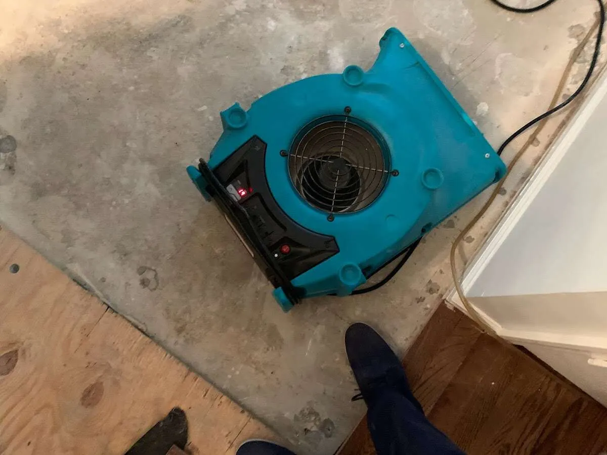 Air mover drying subfloor during Commercial Water Damage Restoration in Addison